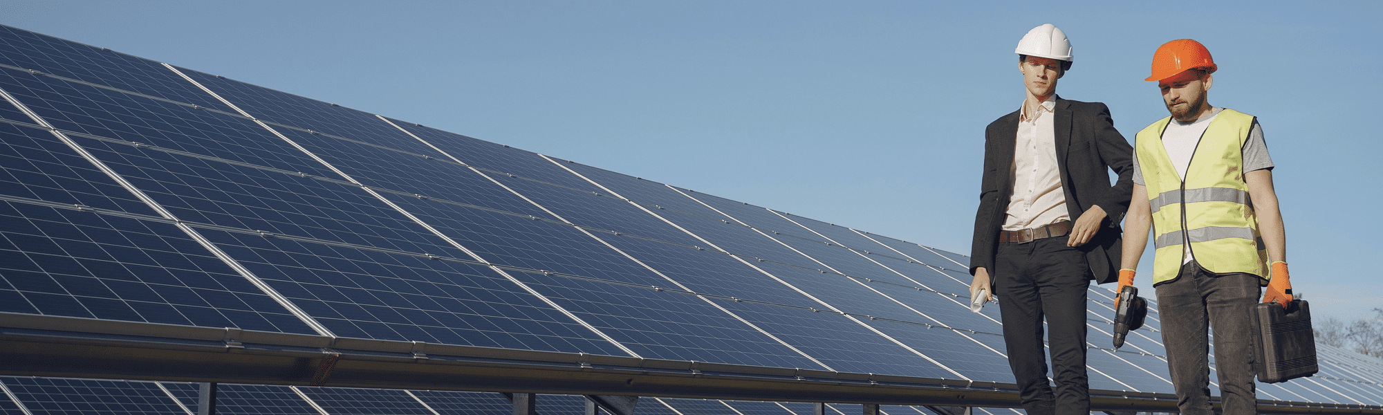 1 business man and one contractor walking alongside some solar panels