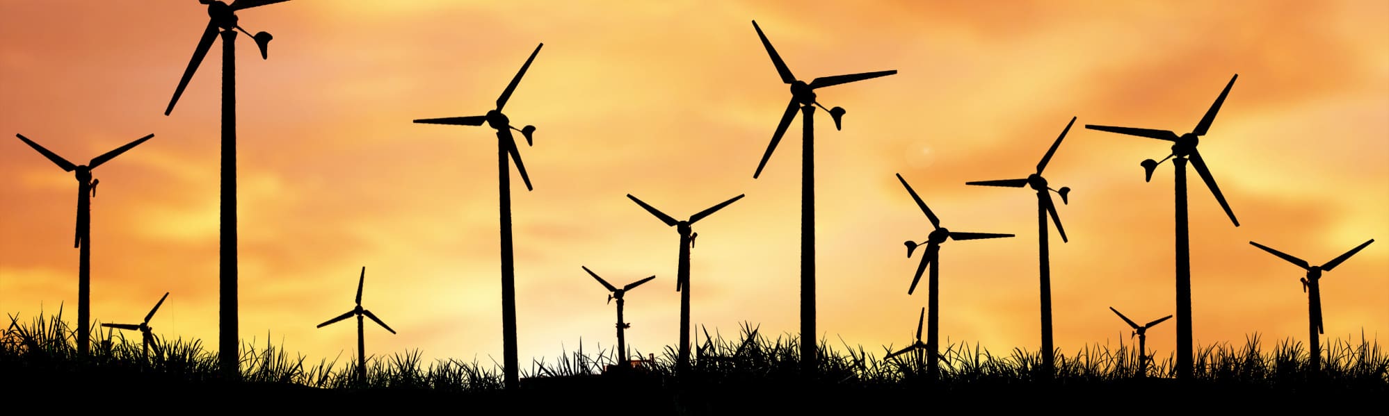 A picture of small wind turbines with an orange sunset background