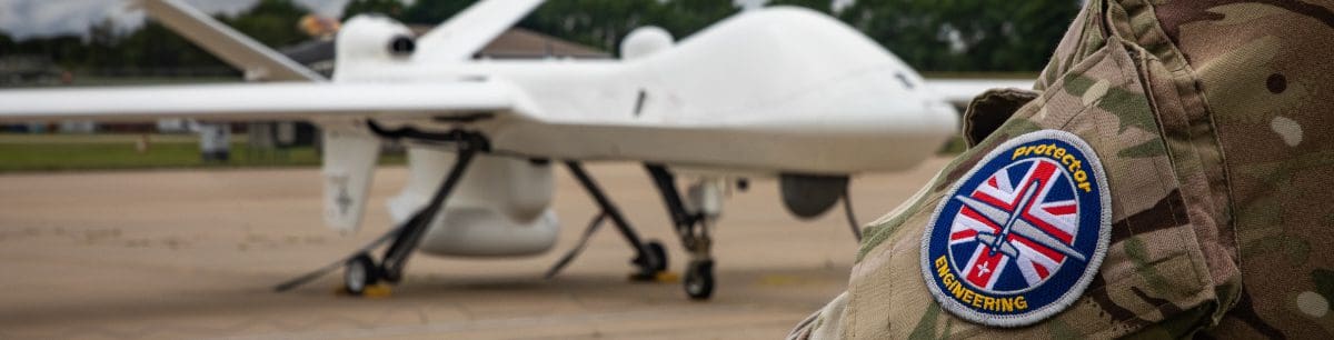 A zoomed in picture of a solider in the Royal Airforce stood looking at a drone