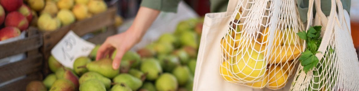 a picture of someone shopping for fruit and veg at a local market