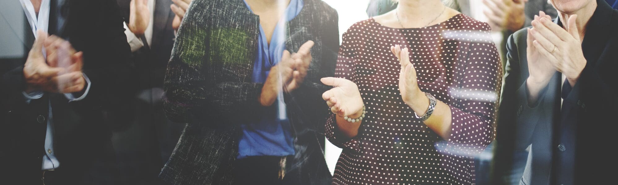 A picture of 4 people clapping, heads not visible