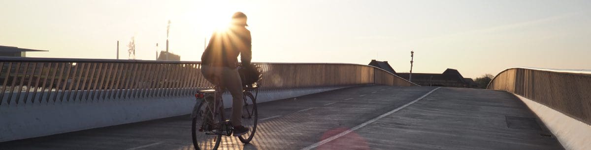 A picture of someone riding their bike on an empty bridge road