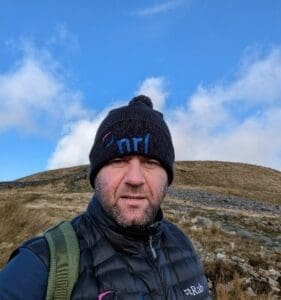 Brett Hawke wearing an NRL hat walking the 3 Peaks in Yorkshire