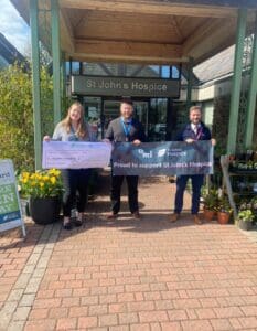 Jack and Nick from Heysham branch hold an NRL banner at St John's Hospice after donating £500.