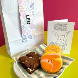 A brownie and 3 personalised biscuits with a bag and card behind. Supporting PSPA for an Easter charity fundraiser