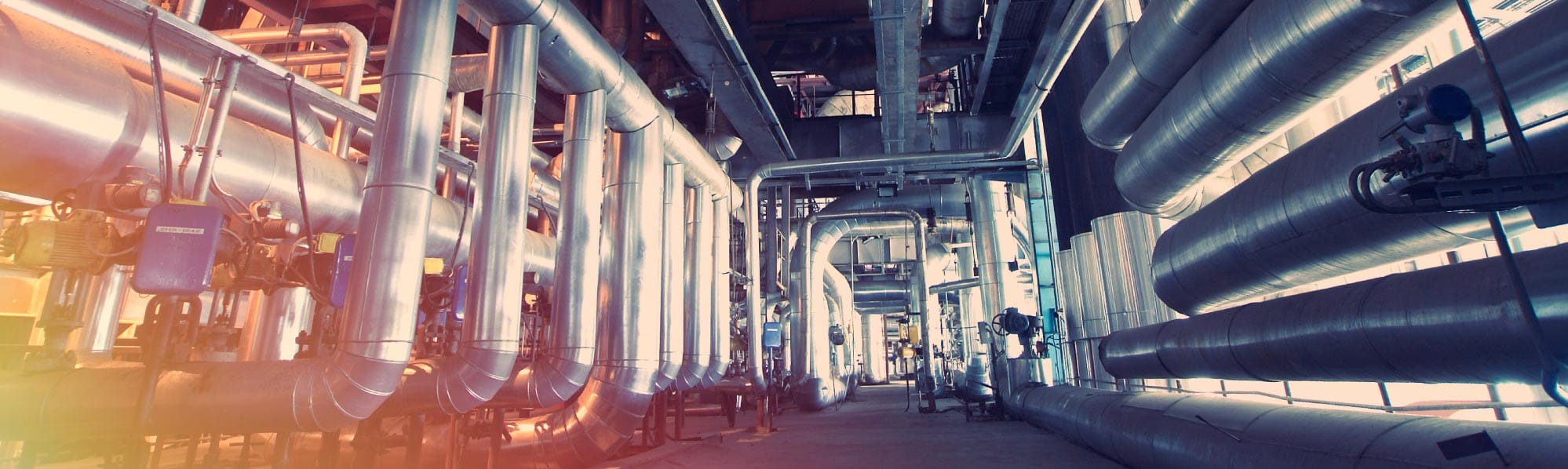 A picture of large shiny steel pipework in a factory