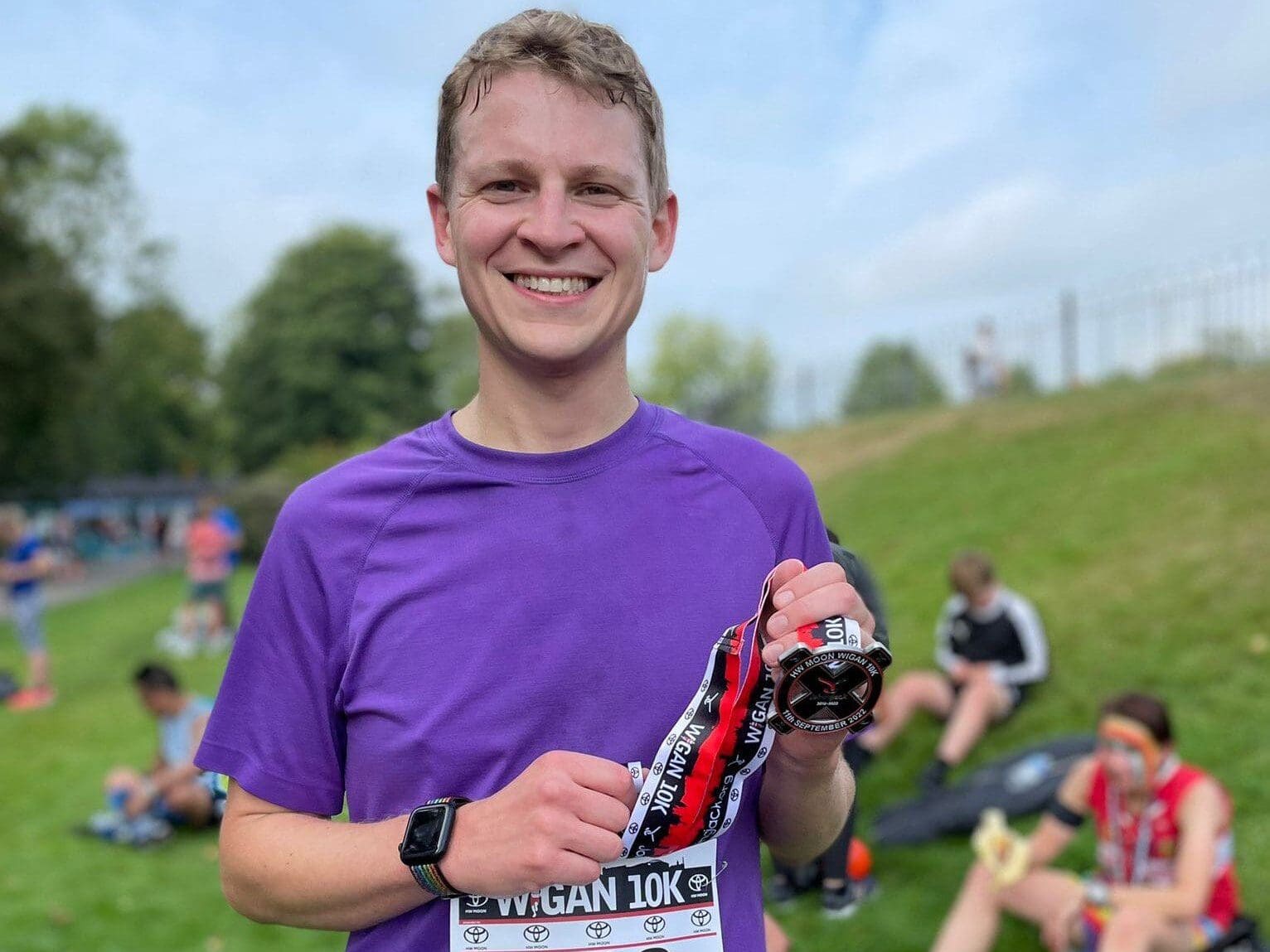 Tim Millbank from our Wigan Team holding a medal after completing the Wigan 10K run