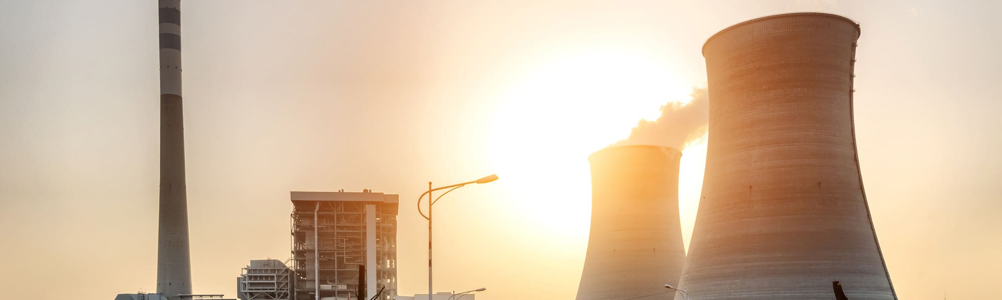Nuclear cooling towers silhouetted against a sunset background.