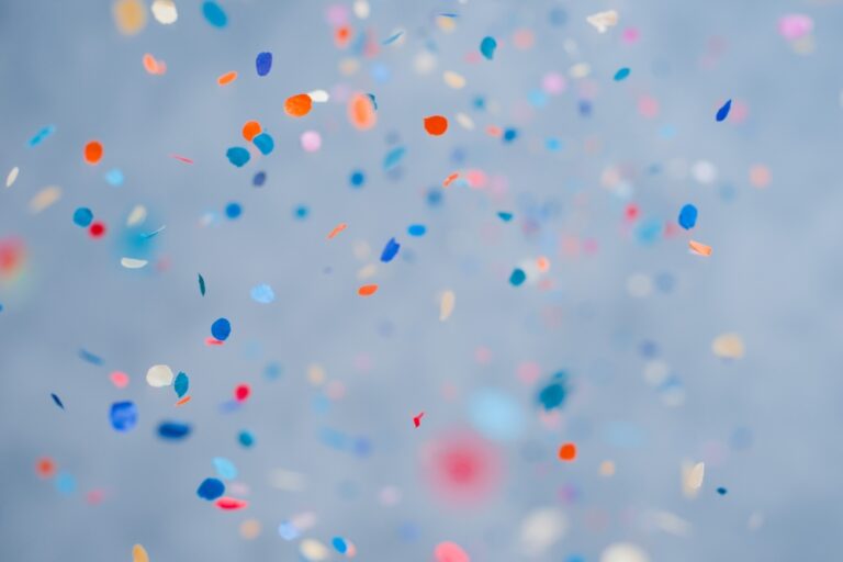Coloured paper confetti scattered and falling against a soft blurred background.